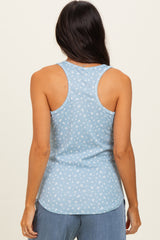 woman wearing a light blue tank top with a white floral pattern and racerback style, shown from the back