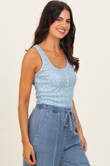 woman wearing a light blue patterned tank top with buttons and high-waisted denim culottes