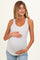 woman wearing a white maternity tank top with small floral print and holding her baby bump