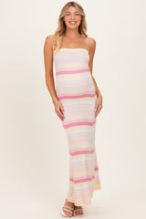 woman wearing a multicolored striped strapless maternity maxi dress with a fitted silhouette and visible baby bump