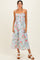 woman wearing a light blue floral sundress with spaghetti straps and a smocked bodice