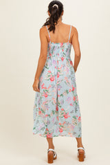 woman wearing a floral smocked midi dress with thin straps and a flowy skirt, view from the back