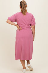 woman wearing a pink maternity plus dress with short puff sleeves and a flowy skirt, view from the back