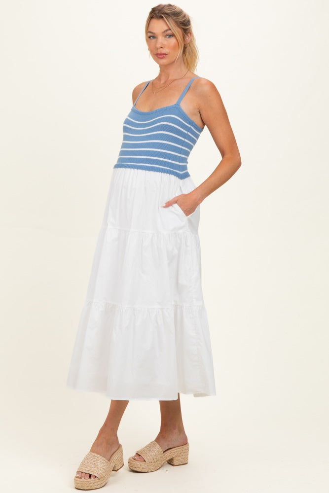 woman wearing a blue and white striped maternity dress with a tiered white skirt and pockets
