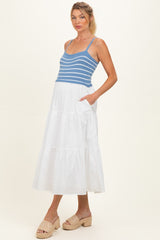 woman wearing a blue and white striped maternity dress with a tiered white skirt and pockets