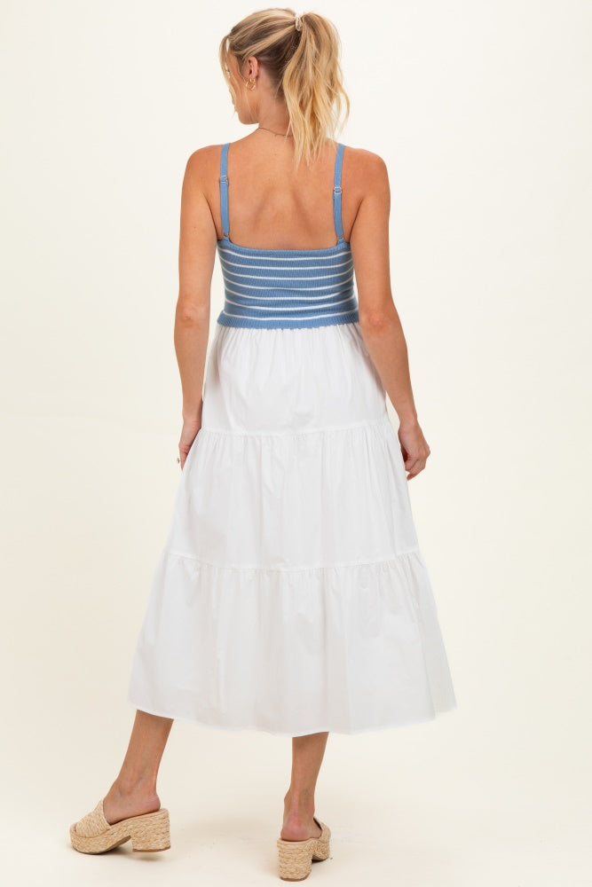 woman wearing a maternity sleeveless white tiered dress with a blue striped bodice, showing her back and a casual hairstyle