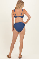 woman wearing a blue bikini set with a bralette top and high-waisted bottom, viewed from the back