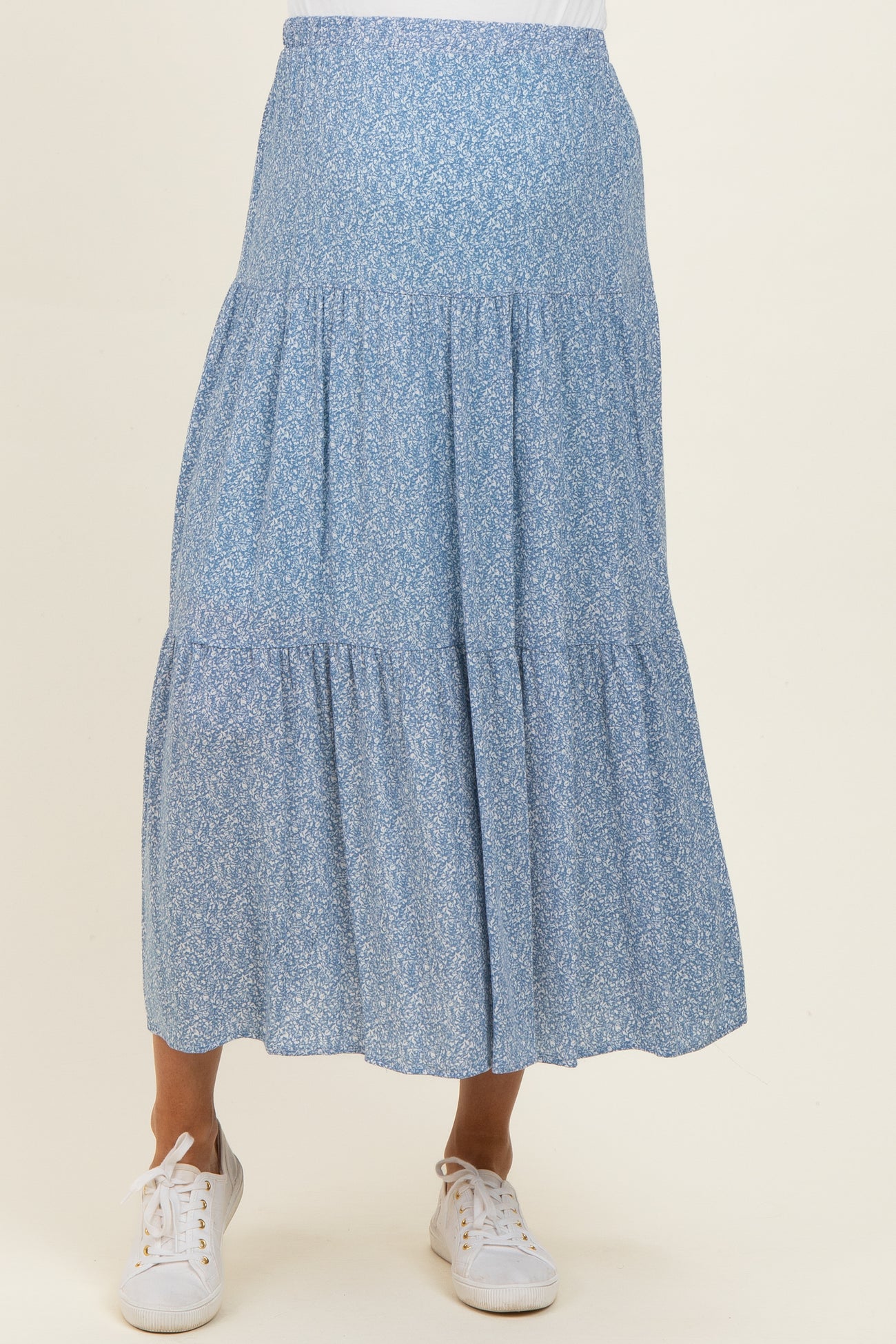 woman wearing a light blue floral maternity skirt with a tiered design and elastic waistband