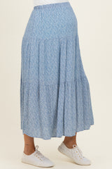woman wearing a light blue floral maternity maxi skirt and showcasing her baby bump