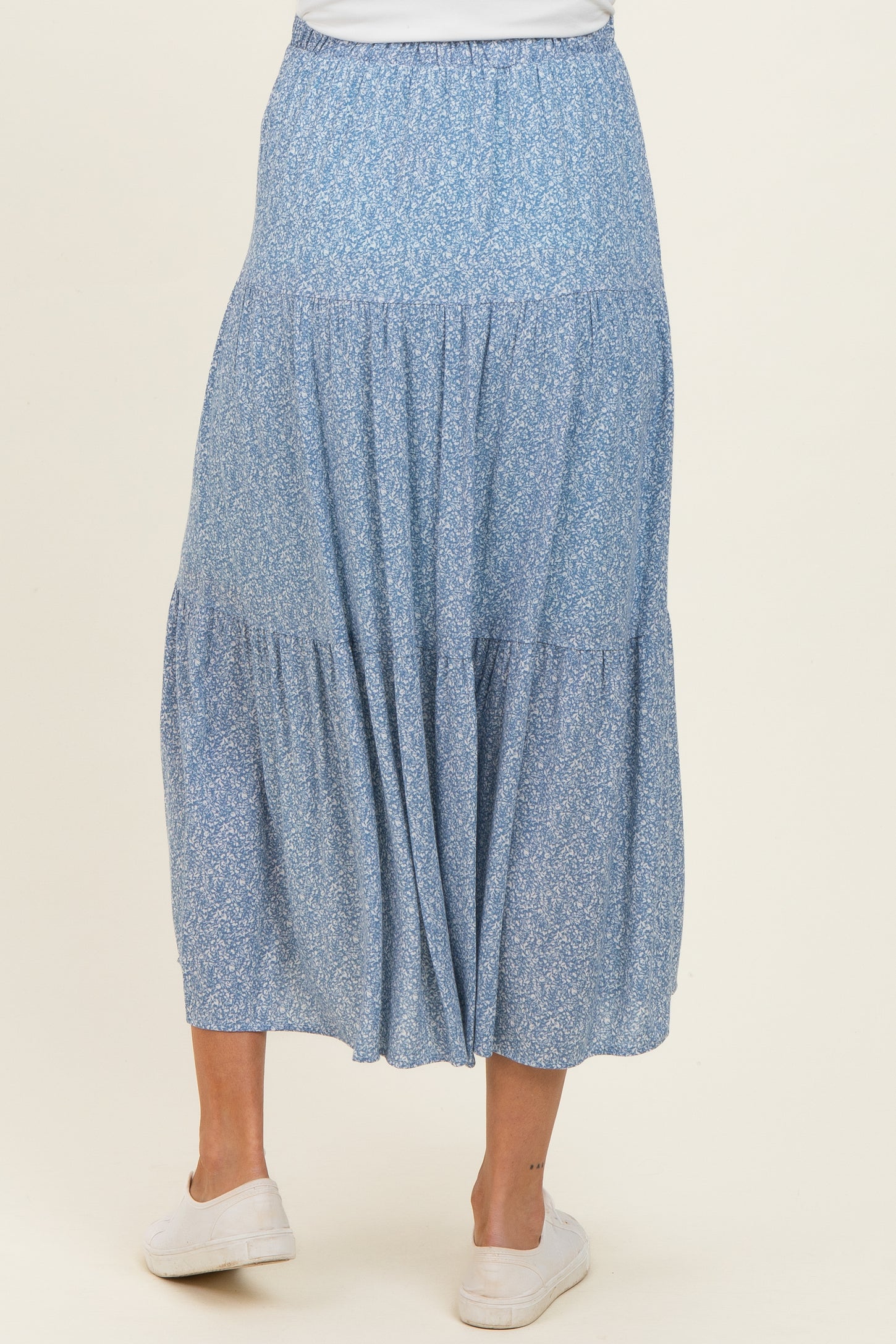 maternity wear flowy blue floral tiered maxi skirt with an elastic waistband, model facing away