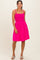 woman wearing a bright pink sundress with a smocked bodice and adjustable straps