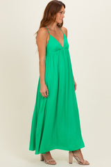 woman wearing a bright green sleeveless maxi dress with a flowy silhouette and a deep v-neckline