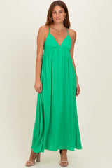woman wearing a vibrant green maxi dress with a plunging neckline and adjustable spaghetti straps