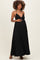 woman wearing a black halter maternity maxi dress and gently holding her baby bump