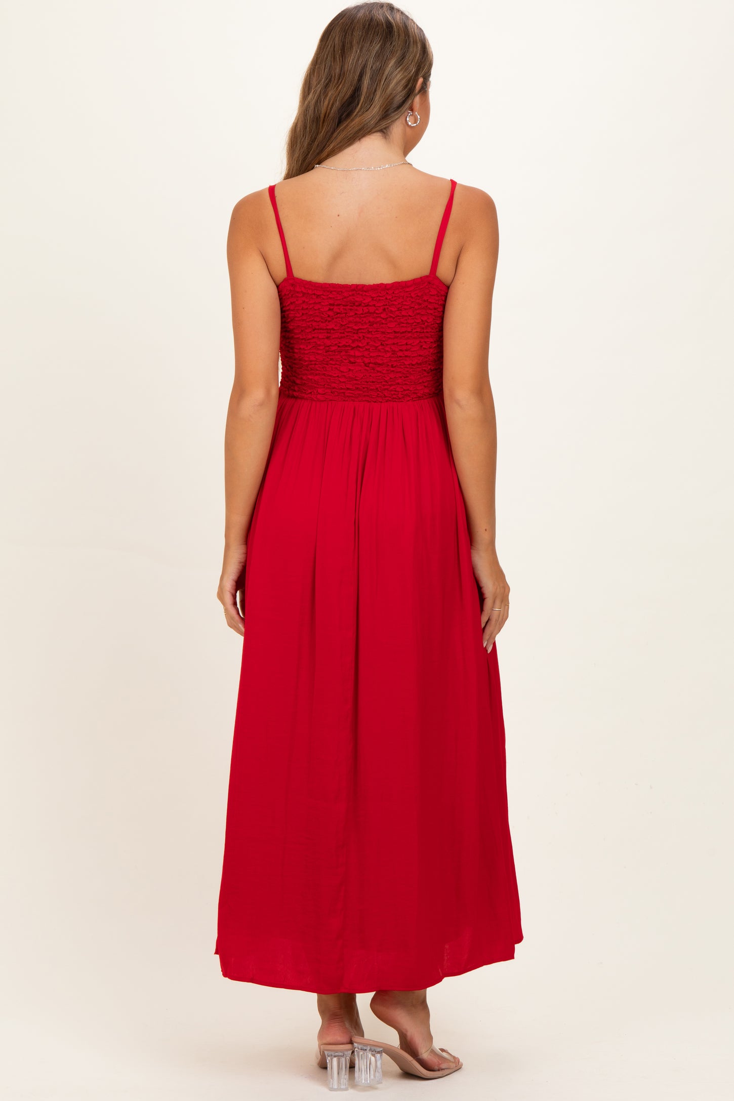 woman wearing a red maternity maxi dress with a smocked bodice and adjustable straps, shown from the back