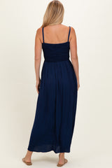 woman wearing a navy blue maxi dress with a smocked bodice and spaghetti straps, seen from the back