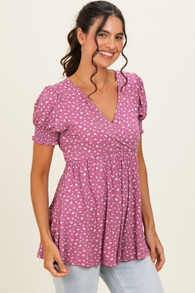 woman wearing a mauve short sleeve peplum top with a floral print and smocked detail