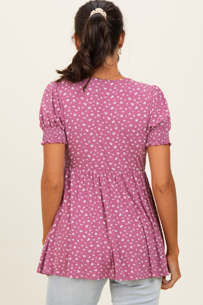 woman wearing a purple short sleeve peplum top with a floral pattern and smocked details on the sleeves