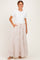 woman wearing a white short sleeve top and a long floral print maxi skirt with pockets