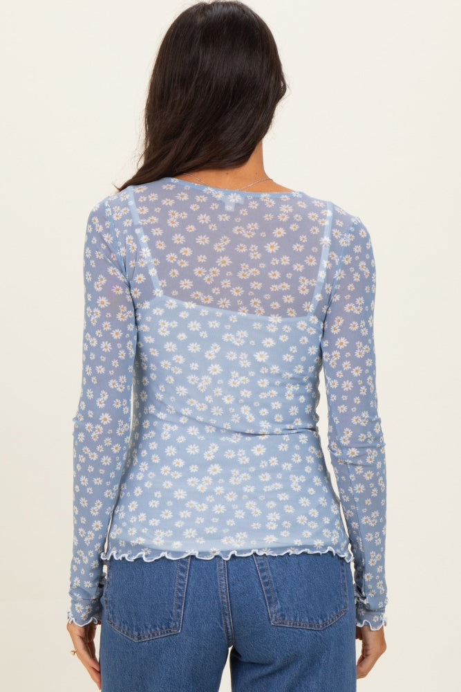 woman wearing a light blue floral sheer long sleeve top with scalloped hem and back design
