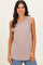woman wearing a light taupe sleeveless textured top with a round neckline and relaxed fit