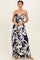 woman wearing a navy blue and white floral print maxi dress with a front tie detail and spaghetti straps