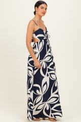 woman wearing a navy blue and cream floral print maxi dress with cutout sides and adjustable straps
