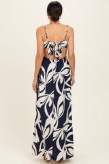 woman wearing a navy blue and white floral maxi dress with a back tie detail and open back