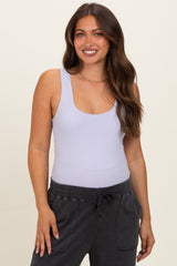 woman wearing a lavender maternity bodysuit with a scoop neckline and black jogger pants