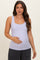 woman wearing a light lavender maternity tank top and holding her baby bump
