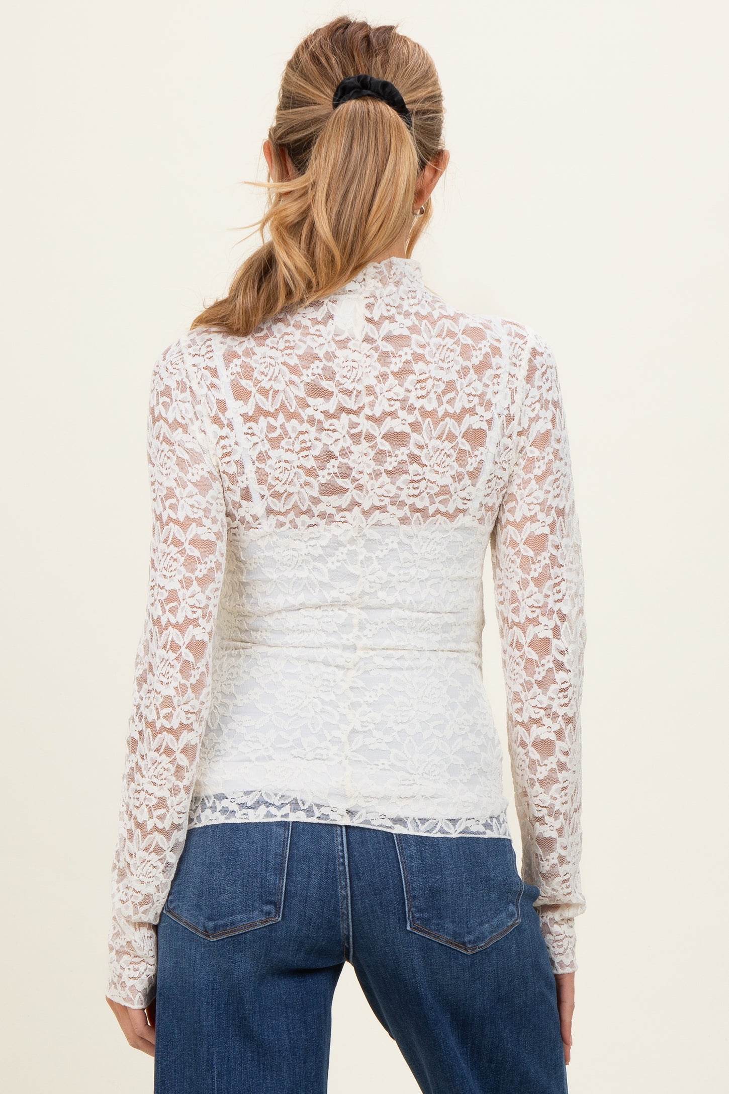woman wearing a white lace maternity top with long sleeves and a fitted design, viewed from the back