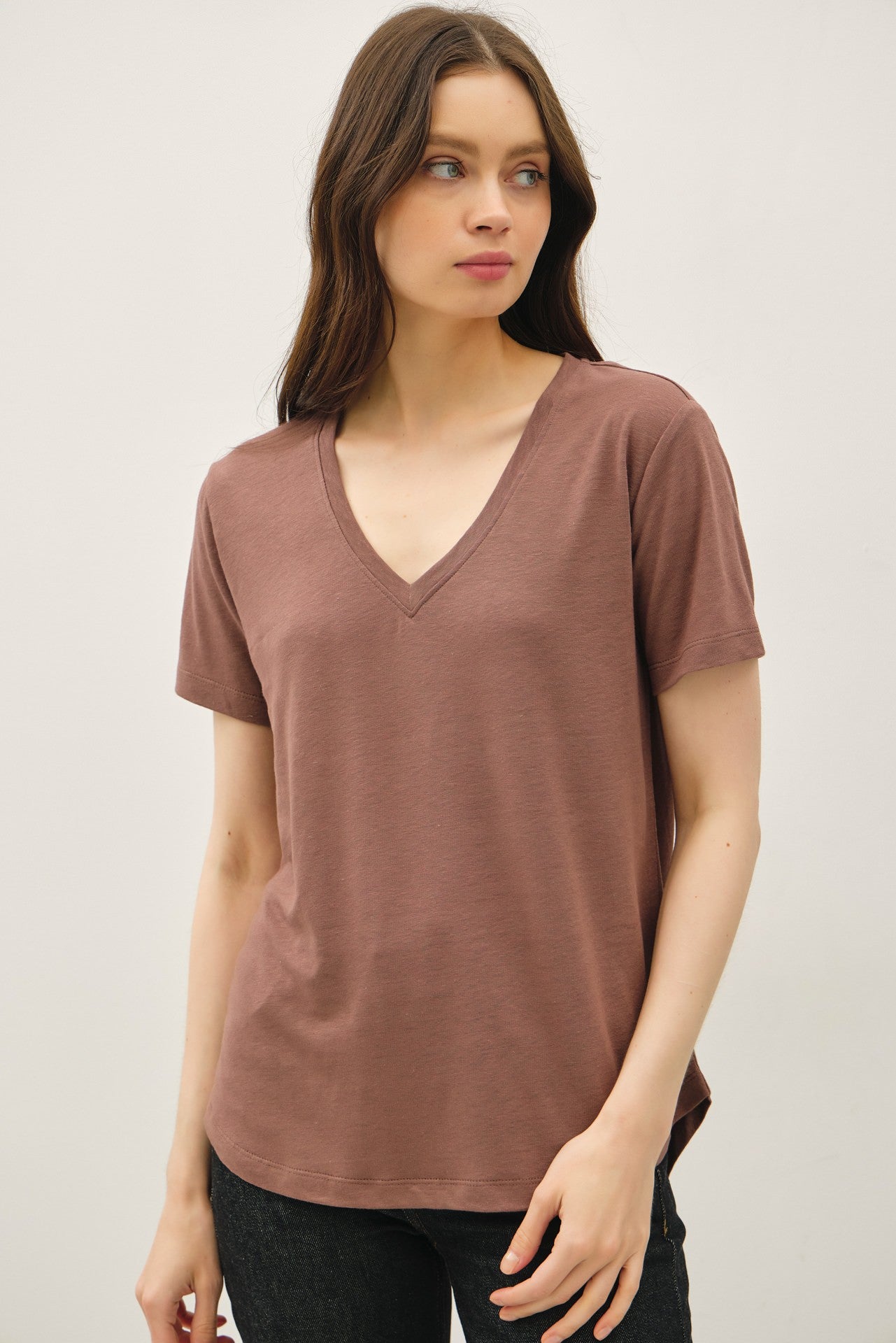 woman wearing a dusty rose v-neck t-shirt with short sleeves and a relaxed fit