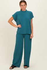 woman wearing a teal ribbed two-piece lounge set with a short sleeve top and wide-leg pants