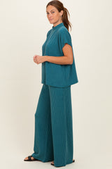 woman wearing a teal two-piece ribbed set with a high neckline and wide-leg pants