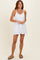 woman wearing a white sleeveless dress with pockets and a relaxed fit
