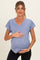 woman wearing a light blue short sleeve maternity top and holding her baby bump