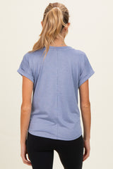 woman wearing a light blue maternity short sleeve top, viewed from the back, styled with rolled cuffs