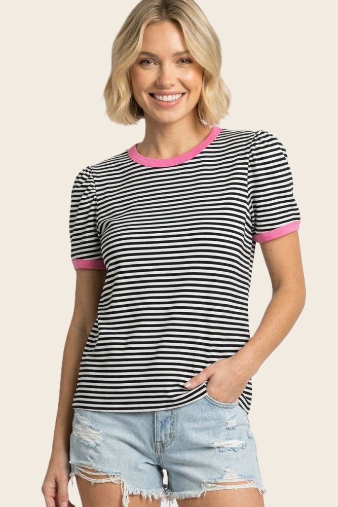 woman wearing a black and white striped t-shirt with pink trim and puff sleeves, paired with denim shorts