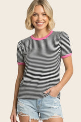 woman wearing a black and white striped t-shirt with pink trim and puff sleeves, paired with denim shorts