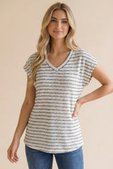 woman wearing a relaxed fit striped v-neck top with short sleeves, styled with blue jeans