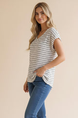 woman wearing a striped short sleeve top with a V-neck and side knot detail, paired with blue jeans