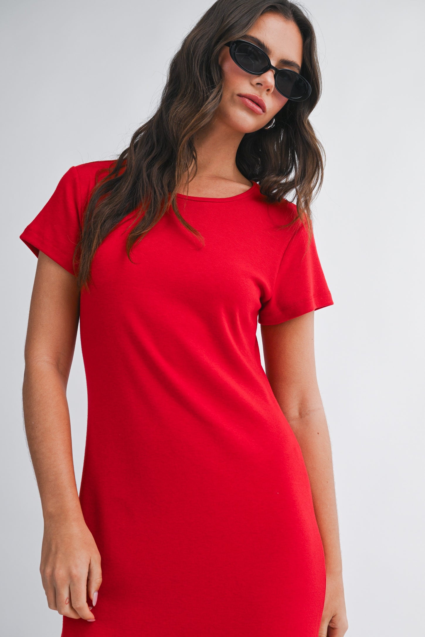 woman wearing a red short sleeve dress with a round neckline and sunglasses
