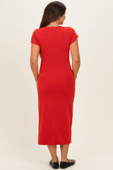 woman wearing a fitted red maternity maxi dress, showing the back view with short sleeves