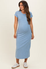 woman wearing a light blue short sleeve maternity dress, showcasing her baby bump, styled with white sneakers