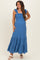 woman wearing a blue maternity maxi dress with ruffle straps and a smocked bodice, showcasing her baby bump