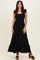 woman wearing a black maxi dress with ruffled sleeves and a tiered hem, standing confidently on a neutral background