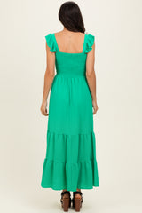 woman wearing a back view of a bright green tiered maxi dress with ruffle straps and a smocked bodice