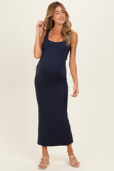 woman wearing a navy blue maternity maxi dress with a fitted silhouette and a visible baby bump