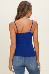 woman wearing a royal blue fitted camisole top with thin straps, styled with light wash jeans
