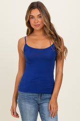 woman wearing a fitted royal blue camisole top with thin straps and straight neckline, paired with light denim jeans